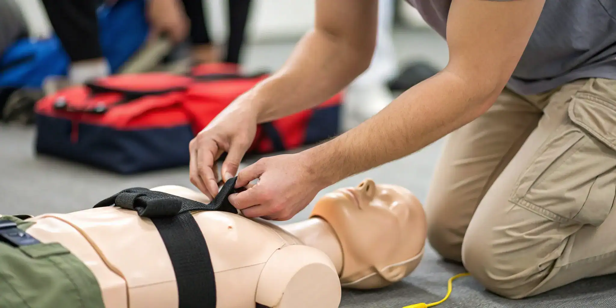Applying a tourniquet on a manikin in a Stop the Bleed certification course.