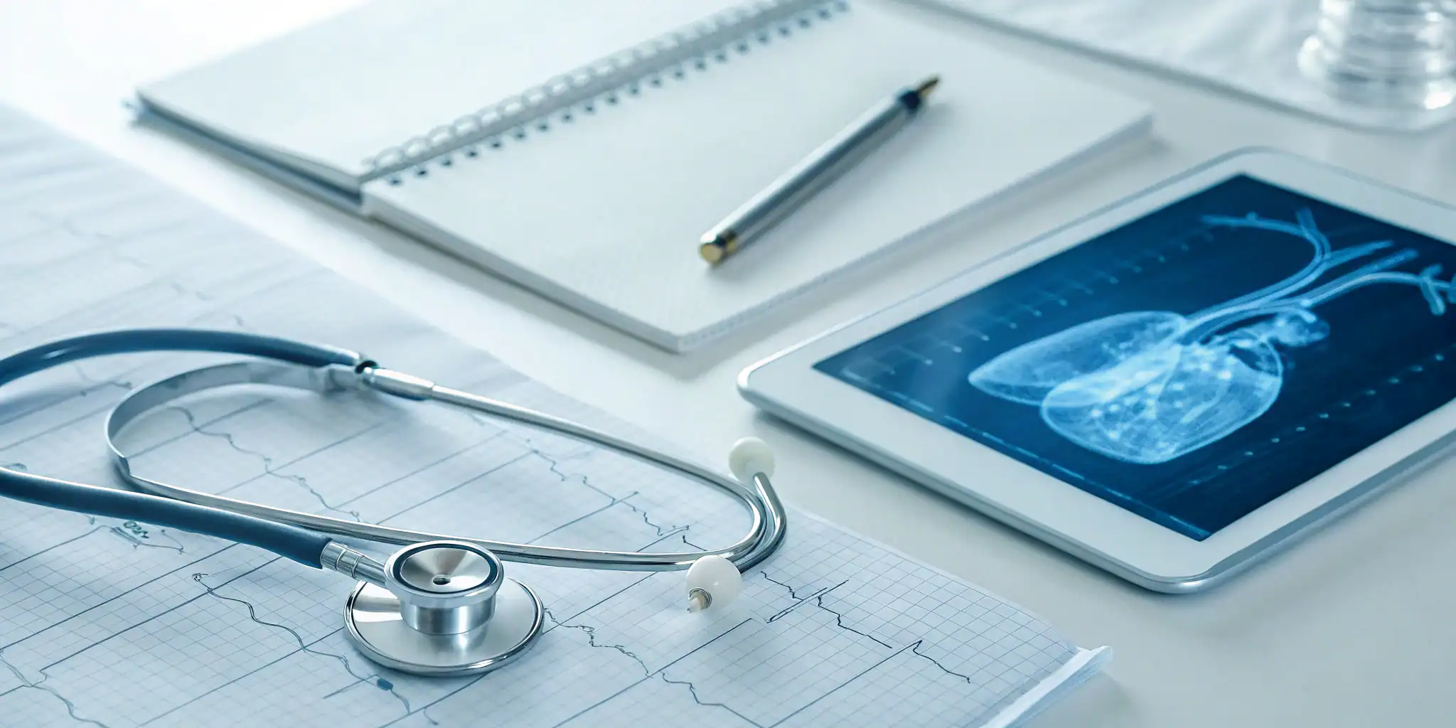 Stethoscope and heart scan on a desk for AED medical director requirements.