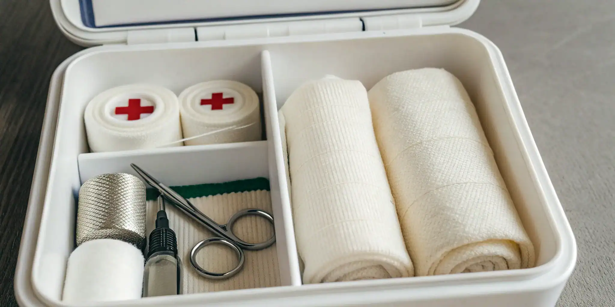 An open, organized ANSI compliant first aid kit for workplace safety.